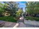 Inviting home featuring a well-maintained lawn, mature trees, and a charming walkway leading to the front door at 1057 N Emerson St # B, Denver, CO 80218
