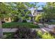 Charming home with a well-manicured lawn and mature trees, framed by a wrought iron fence and blooming bushes at 1057 N Emerson St # B, Denver, CO 80218