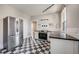 Well-lit kitchen with black and white flooring, stainless steel fridge and appliances, and white cabinetry at 1057 N Emerson St # B, Denver, CO 80218