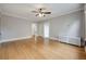 Large living room with wood floors, a ceiling fan, white walls, and classic radiator heaters, offering plenty of space at 1057 N Emerson St # B, Denver, CO 80218
