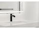 Modern bathroom featuring a sink with minimalist faucet and lit mirror at 11304 Elm Dr, Thornton, CO 80233