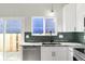 Modern kitchen features white cabinets, stainless steel dishwasher, and unique backsplash tiles at 11304 Elm Dr, Thornton, CO 80233