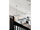 Bright, modern kitchen with white cabinets, stainless steel appliances, and a view from the stairs at 11304 Elm Dr, Thornton, CO 80233