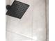 Detail shot of modern shower head with white marbled tile background at 11304 Elm Dr, Thornton, CO 80233