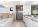 Modern bathroom features separate soaking tub and glass-enclosed shower with dual vanities and natural light at 2038 Meade St, Denver, CO 80211