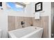 Bright bathroom featuring a soaking tub with tile surround and chrome fixtures at 2038 Meade St, Denver, CO 80211