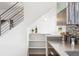 Kitchen area with open shelving, modern cabinets, and a view of the staircase at 2038 Meade St, Denver, CO 80211