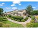 Charming townhome with stone accents, lush landscaping, and inviting walkway on a sunny day at 3795 W 104Th Dr # E, Westminster, CO 80031