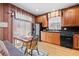 Efficient kitchen with dark appliances, wooden cabinets, and adjacent dining area at 3795 W 104Th Dr # E, Westminster, CO 80031