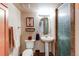 Updated bathroom with pedestal sink, decorative mirror, and tiled shower with glass door at 22261 Pebble Brook Ln, Parker, CO 80138