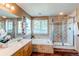 An elegant bathroom boasts tiled walls, a soaking tub, a glass-enclosed shower, and natural light at 22261 Pebble Brook Ln, Parker, CO 80138