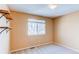 A sunny, carpeted bedroom with neutral walls, shelves, and a large window with blinds at 22261 Pebble Brook Ln, Parker, CO 80138