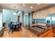 Open-concept kitchen with island cooktop, seating, modern appliances, and adjacent dining area; view of staircase at 22261 Pebble Brook Ln, Parker, CO 80138