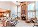 Bright, open-concept living room featuring a soaring ceiling, fireplace, and views into the kitchen at 22261 Pebble Brook Ln, Parker, CO 80138