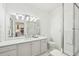 Bright bathroom featuring a glass shower, quartz countertop, large mirror and a view to the kitchen at 2700 E Cherry Creek South Dr # 216, Denver, CO 80209