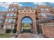 Grand red brick building entrance with an arched entryway, glass doors, and balcony accents at 2700 E Cherry Creek South Dr # 216, Denver, CO 80209