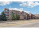 Brick apartment building exterior with multiple balconies under a partly cloudy blue sky at 2700 E Cherry Creek South Dr # 216, Denver, CO 80209