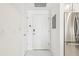 Clean, white hallway with modern fixtures, leading to the front door and featuring stainless steel appliances at 2700 E Cherry Creek South Dr # 216, Denver, CO 80209