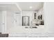 Spacious kitchen featuring white cabinetry, stainless steel appliances, and a quartz countertop breakfast bar at 2700 E Cherry Creek South Dr # 216, Denver, CO 80209
