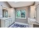 Well-lit bathroom with double vanities, granite countertops, and large windows overlooking the trees at 4856 Cheyenne Dr, Larkspur, CO 80118