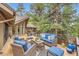 Outdoor deck area with comfortable seating, surrounded by tall trees for privacy at 4856 Cheyenne Dr, Larkspur, CO 80118