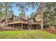 Stunning home featuring a multilevel deck, spiral staircase, manicured lawn, and mature trees at 4856 Cheyenne Dr, Larkspur, CO 80118