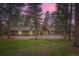 Exterior view of home with stone accents, mature trees, and a circular driveway at 4856 Cheyenne Dr, Larkspur, CO 80118