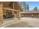 Stone accented front entrance with a covered porch and a three car garage, showcasing great curb appeal at 4856 Cheyenne Dr, Larkspur, CO 80118