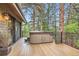 Outdoor hot tub on a wooden deck, surrounded by trees, offering a relaxing space at 4856 Cheyenne Dr, Larkspur, CO 80118