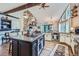 Open kitchen with a stone fireplace, island with cooktop, pendant lighting and stainless appliances at 4856 Cheyenne Dr, Larkspur, CO 80118