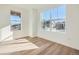 Sunlit bedroom with light wood flooring and large windows offering neighborhood views at 4858 Astor Pl, Brighton, CO 80601