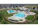 Aerial view of the community pool with seating, playgrounds and landscaped grounds at 4858 Astor Pl, Brighton, CO 80601