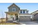 Charming two-story home showcasing a covered porch with stone accents and a neutral color palette at 4858 Astor Pl, Brighton, CO 80601