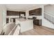 Open kitchen featuring a large island, stainless steel appliances, and modern dark-brown cabinetry at 4858 Astor Pl, Brighton, CO 80601