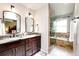 This primary bathroom offers a double vanity, granite countertops, and a beautifully tiled walk-in shower with a separate tub at 9846 Spring Hill Ln, Highlands Ranch, CO 80129