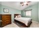 Bedroom with light-green walls and a high ceiling, features carpeted floors, a window and a wooden dresser at 9846 Spring Hill Ln, Highlands Ranch, CO 80129