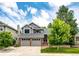 Charming home with a two-car garage, brick accents, and mature trees in a well-manicured front yard at 9846 Spring Hill Ln, Highlands Ranch, CO 80129