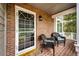Charming front porch with brick accents, a white screen door, and cozy wicker seating at 9846 Spring Hill Ln, Highlands Ranch, CO 80129