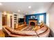 Comfortable living room with a brick fireplace, leather sofa, and hardwood floors at 9846 Spring Hill Ln, Highlands Ranch, CO 80129