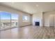 Open living room with a fireplace, a large sliding glass door, and wood-look flooring at 14136 Bunny Hop Ln, Parker, CO 80134