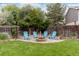 Backyard features a fire pit surrounded by Adirondack chairs, all within a grassy fenced yard at 2763 Dharma Ave, Broomfield, CO 80020