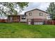 Large backyard with a deck, storage shed, green grass, and a wood fence at 10154 W Hawaii Pl, Lakewood, CO 80232