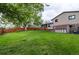 Spacious backyard with mature trees, a deck, a storage shed, and a wooden fence at 10154 W Hawaii Pl, Lakewood, CO 80232
