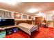Basement bedroom area features a bed, TV, carpeted floor, and wood paneling at 10154 W Hawaii Pl, Lakewood, CO 80232