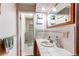 Bathroom featuring white tile counters, a large mirror, and a glass enclosed shower at 10154 W Hawaii Pl, Lakewood, CO 80232