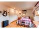 Bright bedroom featuring hardwood floors, a cozy bed, and natural light at 10154 W Hawaii Pl, Lakewood, CO 80232