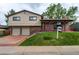 Charming two-story home featuring a brick and siding exterior, attached garage, and well-manicured front lawn at 10154 W Hawaii Pl, Lakewood, CO 80232