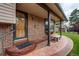Inviting front porch with brick columns, decorative stone flooring, and an elegant wooden front door at 10154 W Hawaii Pl, Lakewood, CO 80232