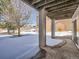 Covered back patio with view of snowy yard at 671 Stafford Cir, Castle Rock, CO 80104