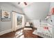 Bedroom with hardwood floors, light-filtering curtains, and a crib at 2841 N Franklin St, Denver, CO 80205